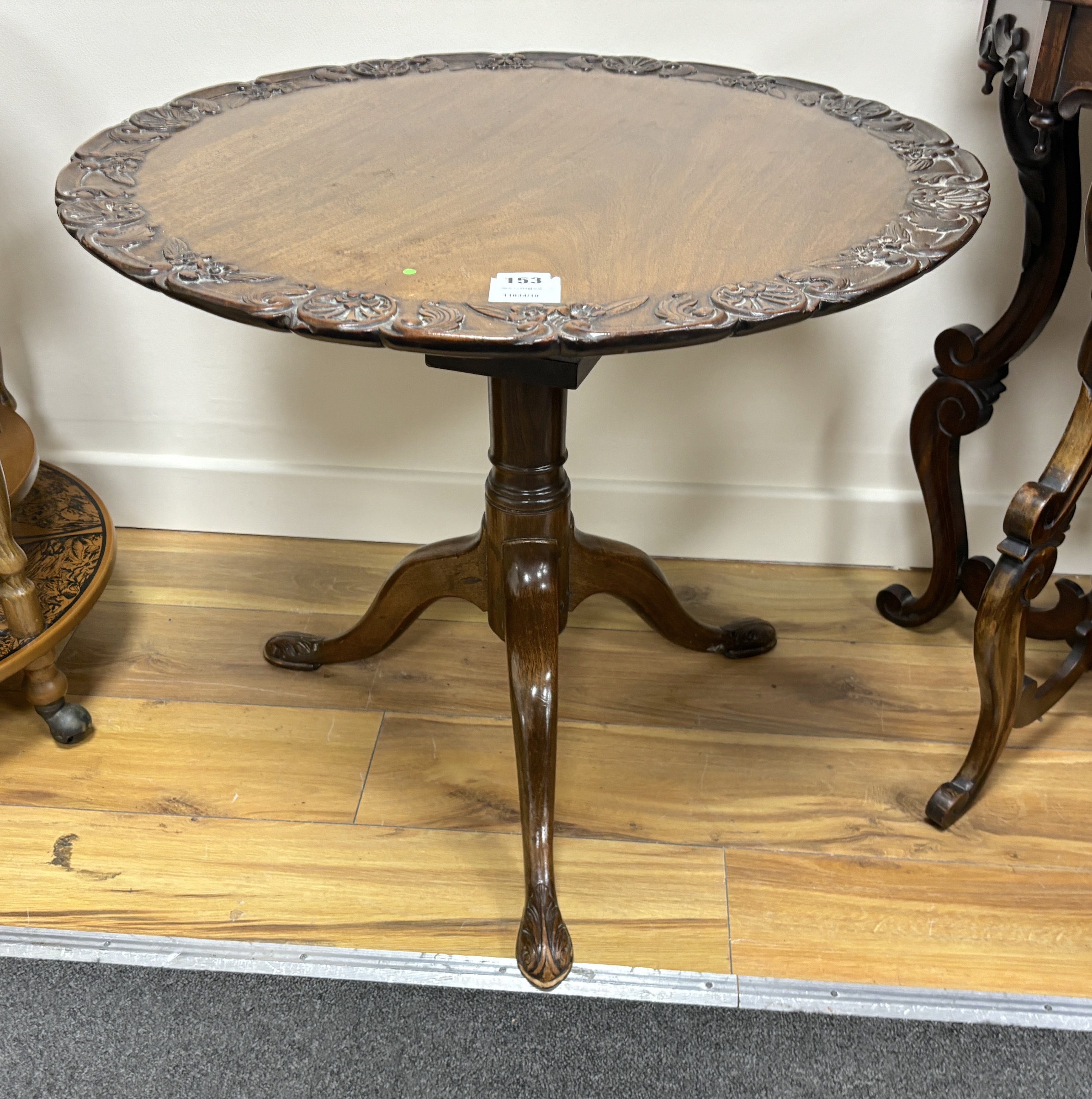 A George III mahogany tea table, on a pillar and ‘’bird cage’’ tripod base, (cut down and repairs to pillar), diameter 66cm, height 56cm